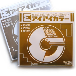 May include: A pack of 100 gold-coloured 15cm by 15cm sheets of paper. The paper is labelled "Craft Custom Culture Common Creation" and "アイアイカラー" in Japanese. The paper is for origami, crafts, and other projects.