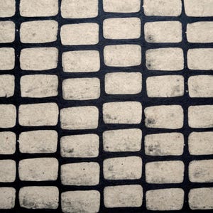 Peut inclure: Gros plan sur une surface texturée avec un motif répétitif de formes rectangulaires. Les rectangles sont de couleur beige clair, sur un fond bleu marine foncé, créant un motif en forme de grille.