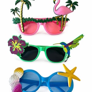 May include: Three pairs of novelty sunglasses with tropical themes. The top pair has pink frames with palm trees and a flamingo. The middle pair has green frames with a flower and a hummingbird. The bottom pair has blue frames with seashells and a starfish.