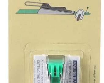 May include: Clover Bias Tape Maker, a green plastic tool for making bias tape, with instructions on a white card. The tool is designed to cut fabric into strips and join them together to create bias tape. The card includes instructions for making bias tapes and a strip width guide.