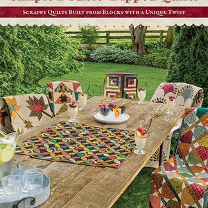 May include: A book titled "Simple Double-Dipped Quilts" by Kim Diehl, featuring a colorful quilt pattern on a table with a pitcher of lemonade and glasses, surrounded by chairs with quilts on them. The book cover features the text "Scrappy Quilts Built From Blocks With A Unique Twist."