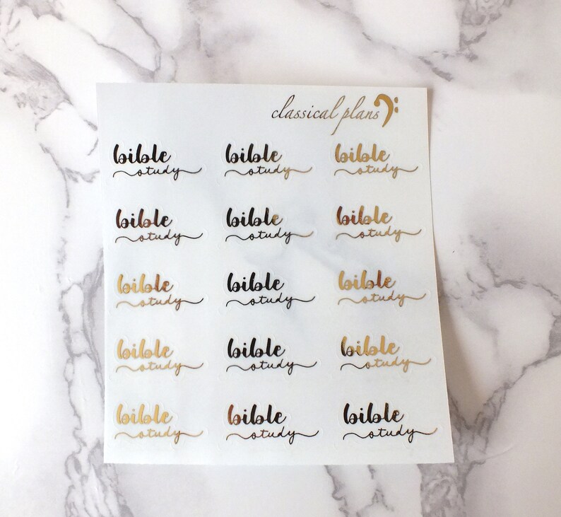 Op de afbeelding: Een vel met transparante stickers met de woorden "bible study" in gouden en zwarte letters. De woorden "classical plans" staan in zwarte cursieve letters bovenaan het vel.