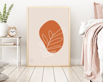 May include: A framed print with a minimalist design featuring a white leaf outline on a terracotta-colored abstract shape against a light beige background.