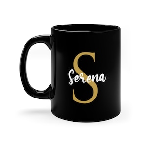 Puede incluir: Taza de cerámica negra con una letra "S" dorada y el nombre "Serena" en escritura cursiva blanca.