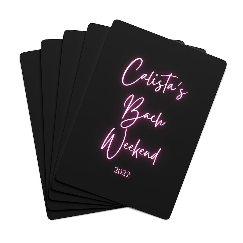 May include: A stack of black cards with pink neon text that reads "Calista's Bach Weekend 2022".