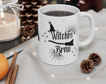 May include: White ceramic mug with a black graphic of a witch's hat, broom, and the text "Witches Brew".