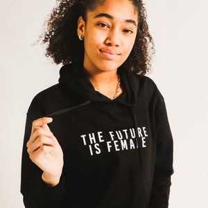 Il futuro è felpa con cappuccio femminile. felpa con cappuccio nera, unisex, cotone/poliestere, marcia donna, festa della donna, streetwear, citazione, uguaglianza