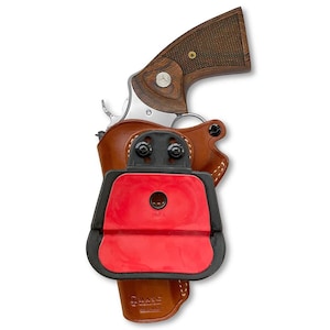 May include: A brown leather holster with a black plastic clip and a red rubber insert. The holster is designed to hold a revolver with a wooden handle. The holster is labeled "MASC" and "Hand Made".