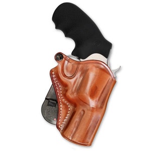 May include: A brown leather holster with a stitched edge and a white thread. A silver revolver with a black rubber grip is inside the holster.