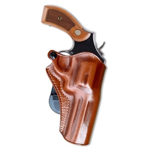 May include: A brown leather holster for a handgun. The holster has a belt loop and a snap closure. The holster is designed to be worn on the hip.
