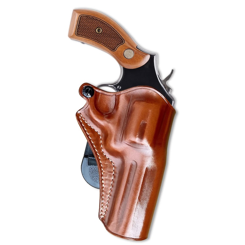 May include: A brown leather holster for a handgun. The holster has a belt loop and a snap closure. The holster is designed to be worn on the hip.