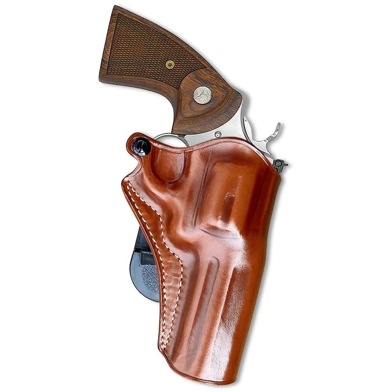 May include: A brown leather holster with a stitched design, holding a silver revolver with a wooden grip.