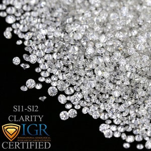 May include: A close-up of a pile of SI1-SI2 clarity diamonds. The diamonds are clear and sparkling, with many facets visible. The image includes the text "SI1-SI2 CLARITY IGR CERTIFIED".