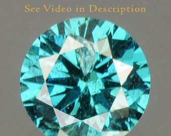 Puede incluir: Una gema redonda y facetada de color turquesa vibrante. La gema tiene una estructura interna compleja con múltiples facetas, creando un efecto brillante. La imagen incluye el texto "See Video in Description" y un logotipo que dice "IGR Certified".
