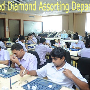 May include: An interior shot of a diamond sorting department. Several people are seated at tables, examining diamonds with magnifying glasses and small tools. The text "Polished Diamond Assorting Department" is at the top of the image.