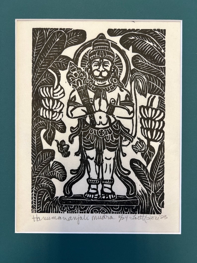 May include: Black and white woodcut print of a Hindu deity with a crown and a beard, standing with hands clasped in prayer. The deity is surrounded by stylized foliage. The print is titled "Hanumananjali mudra 7/4 Satish 2023".