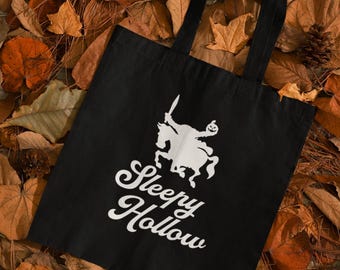 May include: Black tote bag with a white graphic of a headless horseman riding a horse and the text "Sleepy Hollow".