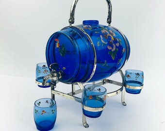 May include: A cobalt blue glass barrel with painted floral and rooster designs, on a silver stand with four matching cobalt blue shot glasses.