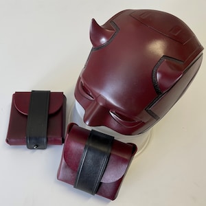 May include: A red and black Daredevil mask with two small red and black pouches.