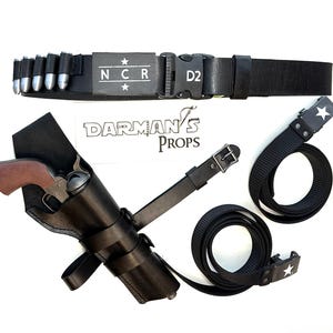 May include: A black leather gun holster with a brown handle revolver. A black belt with silver bullets and the letters "NCR" and a star. Two black belts with white star buckles are also included.