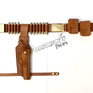 May include: A brown leather belt with a holster, ammo loops, and two pouches. The belt has a gold buckle with the text "DARMAN'S PROPS".