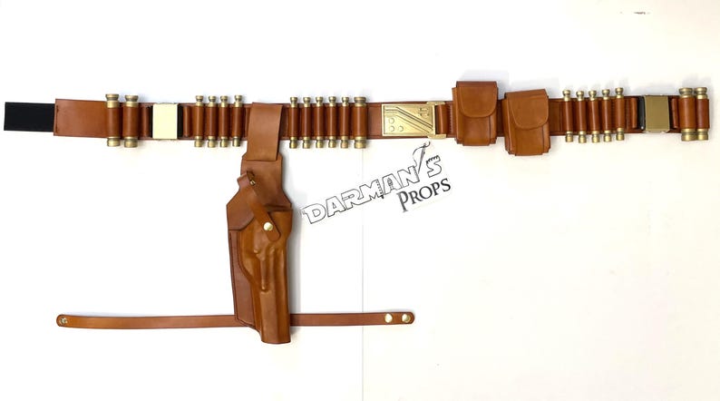 May include: A brown leather belt with a holster, ammo loops, and two pouches. The belt has a gold buckle with the text "DARMAN'S PROPS".