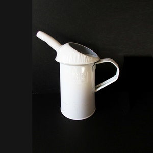 May include: White metal one gallon jug with a spout and handle. The jug has the text "1/10 EDGE GALLOW FLUID" printed on the side.