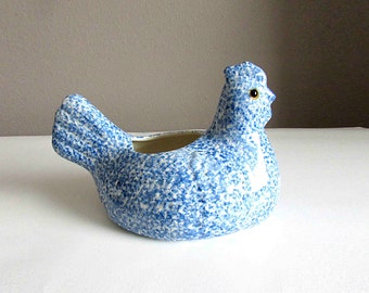 May include: Blue and white speckled ceramic chicken planter. The chicken has a white beak and a yellow eye.