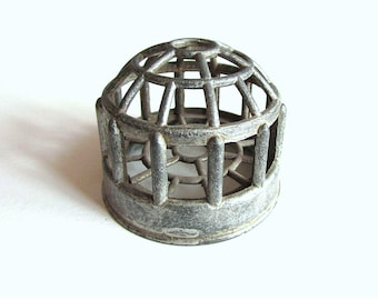 May include: A small, antique-style metal cage with a domed top and vertical bars. The cage has a weathered, gray finish and a circular base. The design features an openwork pattern, suggesting a decorative or ornamental purpose.