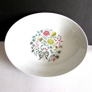May include: White oval serving bowl with a floral design in shades of green, yellow, pink, and red. The design features a bouquet of flowers with a bow in the center.