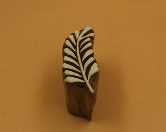 May include: A wooden block printing stamp featuring a white leaf design. The stamp is carved from wood and has a natural brown colour.