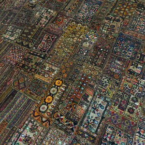 May include: A colorful patchwork quilt with intricate embroidery and small mirrors. The quilt is made of various fabrics in shades of brown, red, green, blue, and yellow. The quilt is a traditional Indian craft.