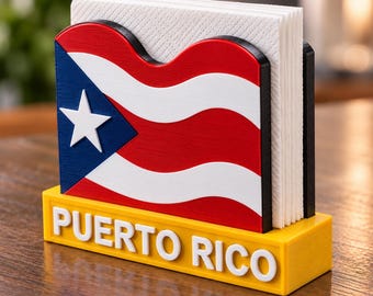Puede incluir: Un servilletero con el diseño de la bandera de Puerto Rico en colores rojo, blanco y azul. La base es amarilla con el texto blanco PUERTO RICO en relieve en la parte frontal. Contiene una pila de servilletas de papel blanco en posición vertical.