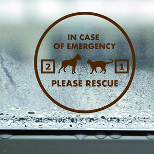 May include: A brown circle sticker on a window with condensation. The sticker says "In case of emergency, please rescue" with a dog and cat silhouette and numbers 1 and 2.