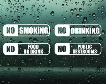 Puede incluir: Cuatro letreros rectangulares blancos con texto negro sobre un fondo borroso de gotas de agua. Los letreros dicen "No Smoking", "No Drinking", "No Food or Drink", y "No Public Restrooms".