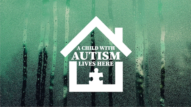 May include: A white house-shaped sticker with the text "A child with autism lives here" and a jigsaw piece inside. The sticker is on a green background with water droplets.