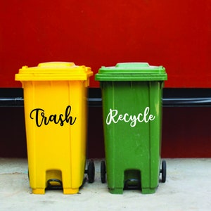 May include: Two trash cans, one yellow with the word "Trash" and one green with the word "Recycle" on the side.