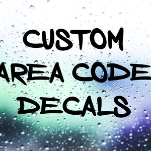May include: The image displays the text "CUSTOM AREA CODE DECALS" in bold, black lettering. The background is a blurred, colorful gradient of blues and greens, with water droplets creating a textured effect. The decals are likely for vehicles or personal items.