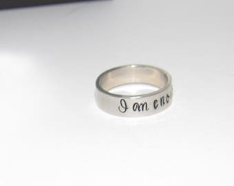 May include: A silver ring with the inscription "I am enough" engraved on the band.