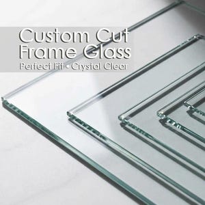 May include: Several clear, rectangular glass panes of varying sizes are arranged diagonally. The text "Custom Cut Frame Glass" is displayed above the words "Perfect Fit • Crystal Clear". The glass appears to be transparent and reflects light.