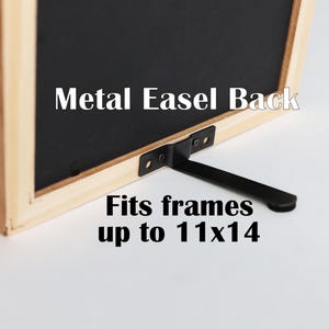 May include: A black metal easel back attached to a light-colored wooden frame. The text on the image reads Metal Easel Back and Fits frames up to 11x14 inches. The easel features a flat, hinged support arm designed for tabletop display.