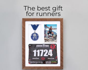 Può includere: Cornice in legno con medaglia Spartan Race, pettorale con numero 11724 e foto di un corridore. Il testo "The best gift for runners" è in alto.
