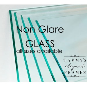 May include: Stack of clear non-glare glass sheets.  The text "Non Glare GLASS all sizes available" is printed on the glass.  The text "TAMMY'S elegant FRAMES" is printed below the glass.