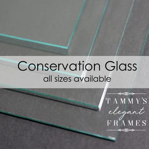 May include: Close-up of several pieces of clear conservation glass, stacked on top of each other. The text "Conservation Glass" and "all sizes available" is printed on a white banner in front of the glass. The text "TAMMY'S elegant FRAMES" is printed below the glass.