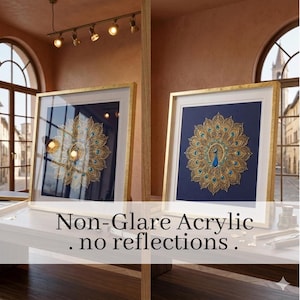 May include: Two framed artworks with gold frames and a peacock feather design on a dark blue background. The artwork features gold and teal accents. The text "Non-Glare Acrylic. no reflections." is visible at the bottom of the image.