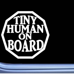May include: White octagon-shaped sticker with the text "Tiny Human On Board" in black lettering.