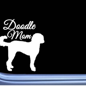 May include: White vinyl decal with the text "Doodle Mom" and a silhouette of a doodle dog.