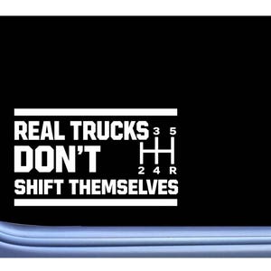 May include: White decal with the text "REAL TRUCKS DON'T SHIFT THEMSELVES" and a gear shift pattern. The decal is on a black background, with a rounded corner shape.