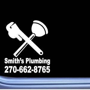 May include: White vinyl sticker with a wrench and plunger crossed over each other. The text "Smith's Plumbing" and the phone number "270-662-8765" are below the tools.