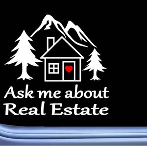 May include: White graphic on a black background. The design features a house with a heart on the door, mountains, and trees. Text reads "Ask me about Real Estate."